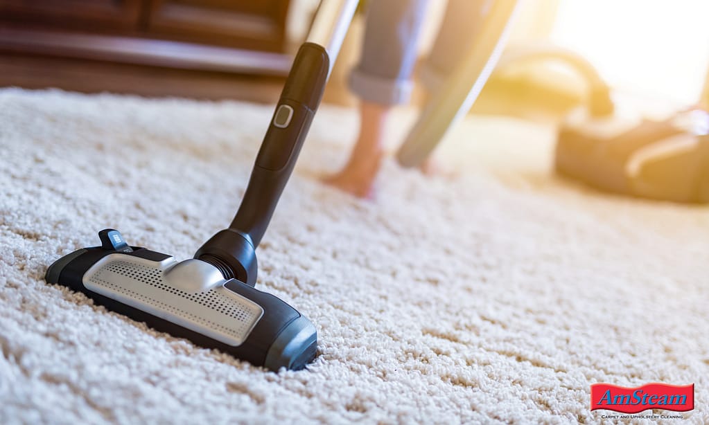 A woman vacuuming an area rug